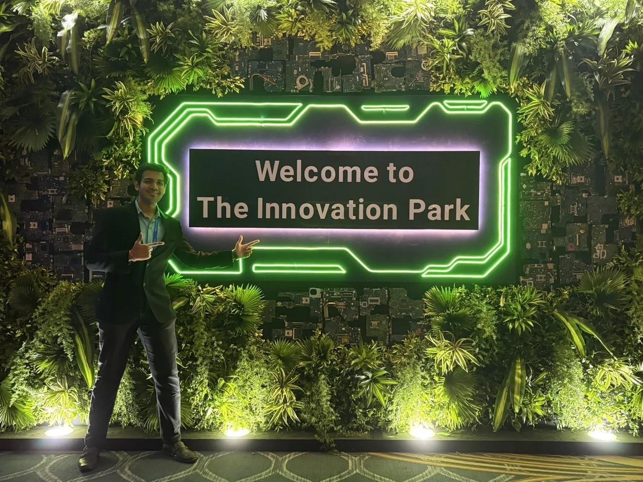Hitansh pointing at a neon Innovation Park sign