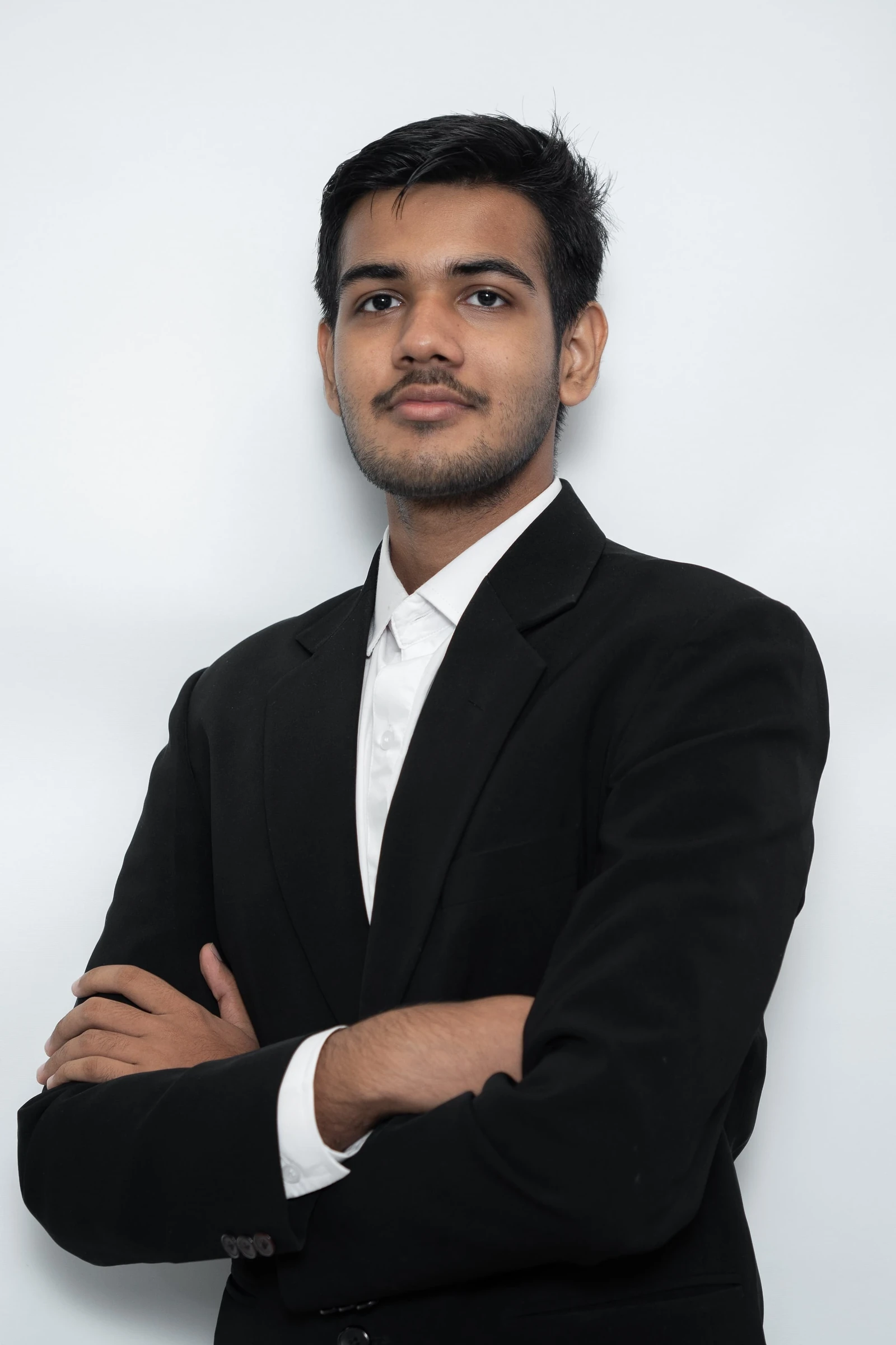 Hitansh Gopani in a black suit, arms crossed